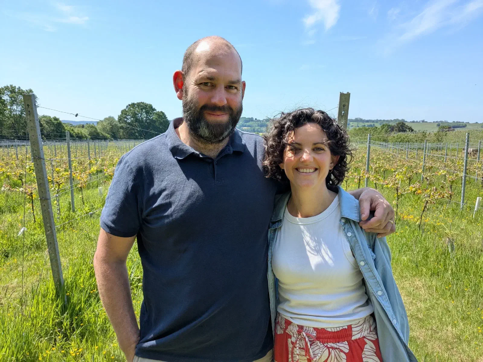 Alastair and Alex smiling in a vineyard on a sunny spring day