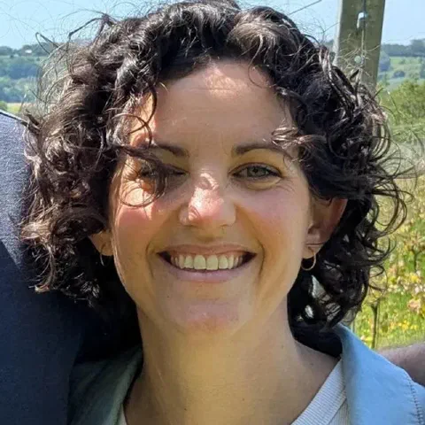 Alex Bursey smiling in a vineyard