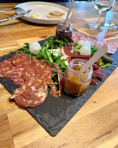 A slate of salami, cured meats, mozzarella, rocket and chutney
